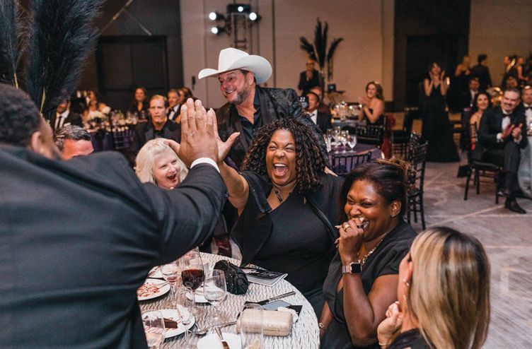 A lucky bidder wins it all at the Black and White Ball. PHOTO BY: CARHART PHOTOGRAPHY